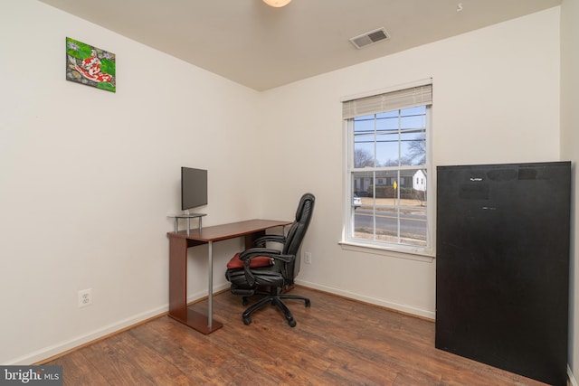 office area with wood finished floors, visible vents, and baseboards