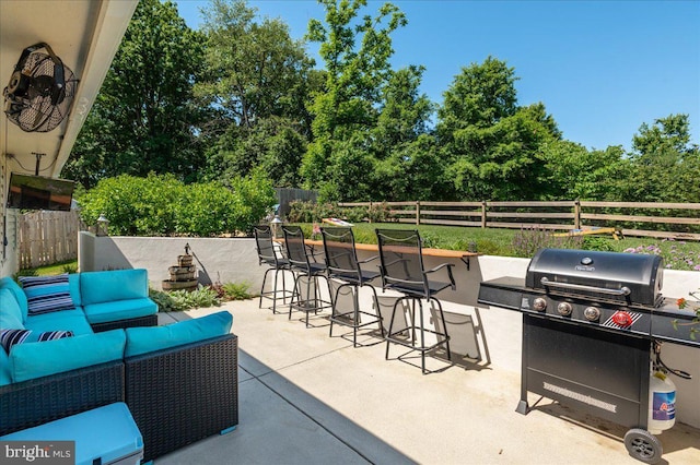 view of patio with area for grilling, outdoor dry bar, fence, exterior kitchen, and an outdoor living space