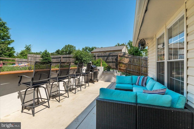 view of patio featuring outdoor dry bar, outdoor lounge area, a fenced backyard, and grilling area