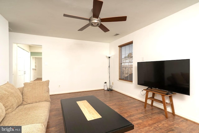 living area with a ceiling fan, baseboards, visible vents, and wood finished floors