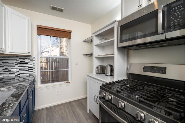 kitchen featuring stainless steel appliances, visible vents, backsplash, white cabinetry, and blue cabinets