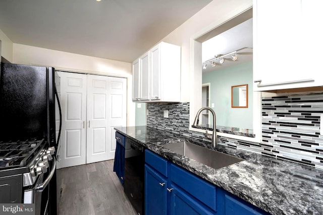 kitchen featuring blue cabinetry, white cabinetry, a sink, dark stone counters, and black appliances