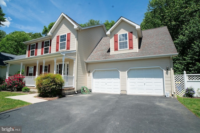 view of front of house featuring aphalt driveway, covered porch, roof with shingles, and an attached garage