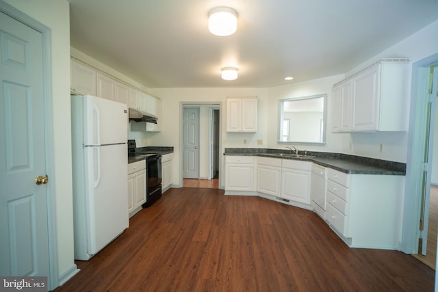 kitchen with white appliances, dark countertops, a sink, and white cabinetry