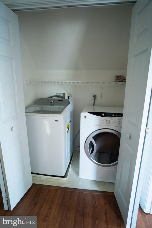 washroom with laundry area, wood finished floors, and independent washer and dryer