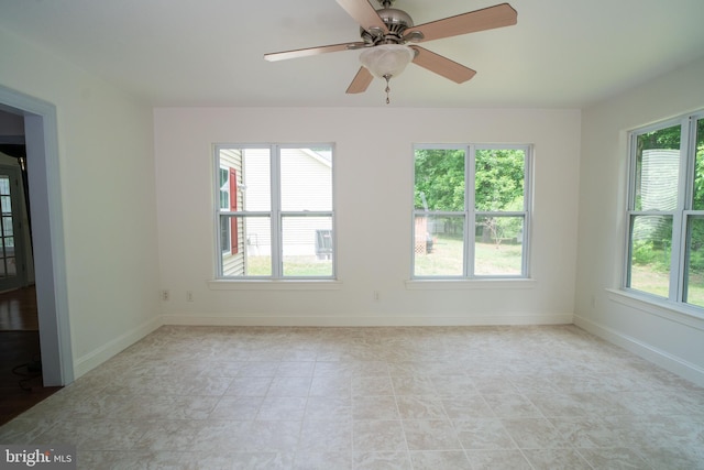 empty room featuring plenty of natural light and baseboards