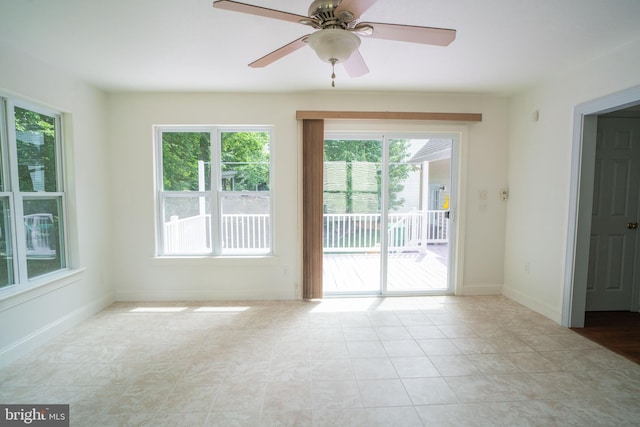 spare room featuring a ceiling fan, tile patterned flooring, and baseboards