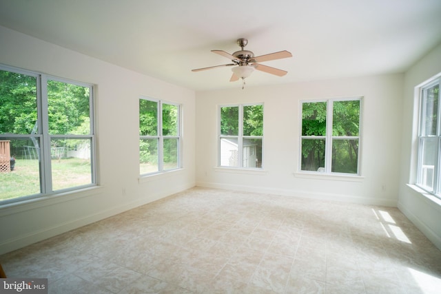 unfurnished sunroom featuring a healthy amount of sunlight and ceiling fan