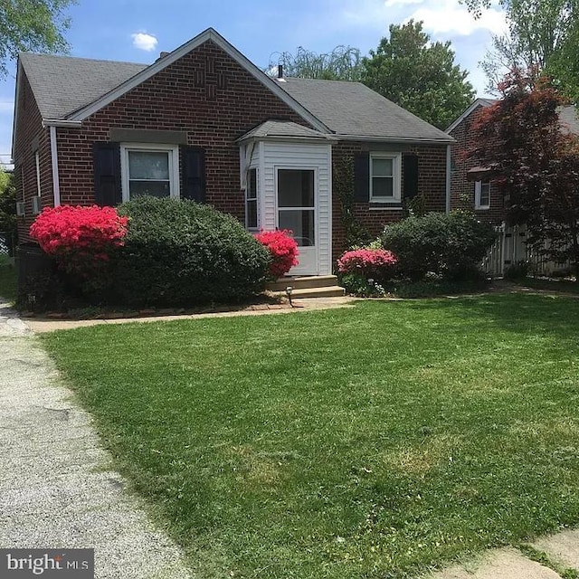 view of front of property featuring brick siding and a front yard