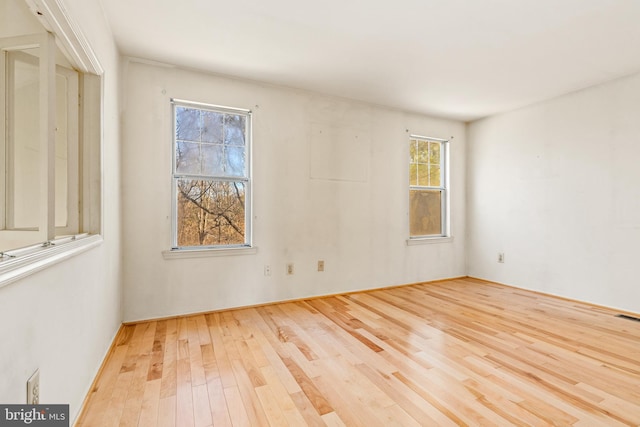 unfurnished room featuring wood finished floors and visible vents