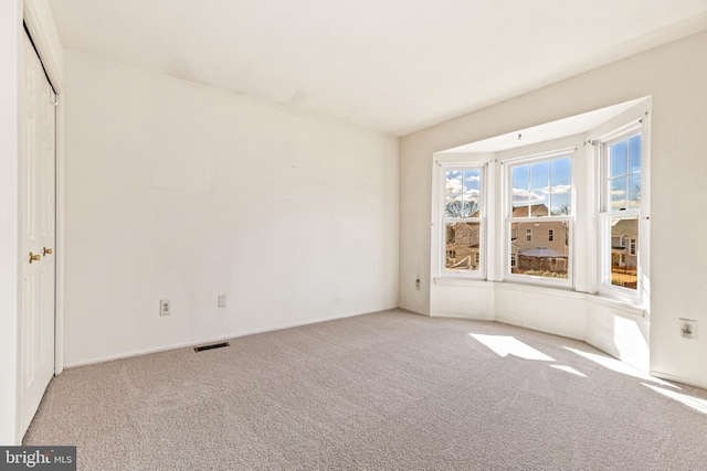 unfurnished bedroom featuring carpet floors and visible vents