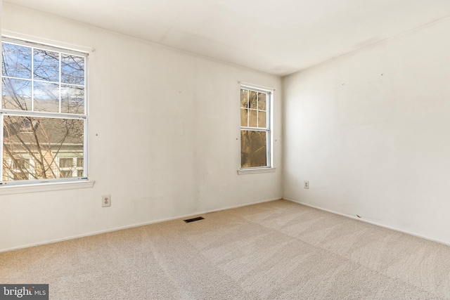 spare room featuring visible vents and carpet flooring