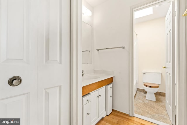 bathroom with vanity, toilet, and wood finished floors