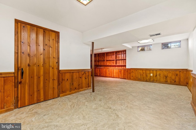 empty room with a wainscoted wall and wood walls