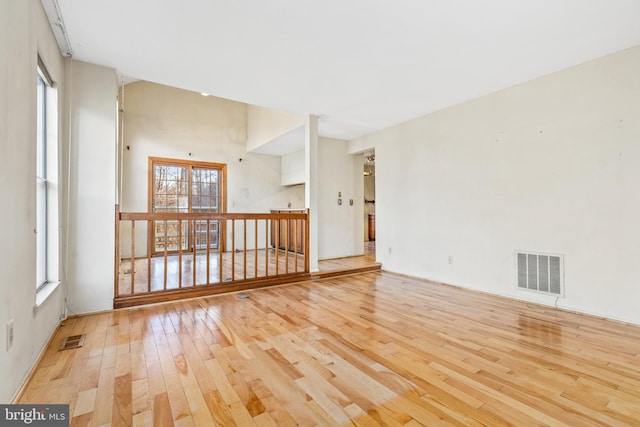 empty room with hardwood / wood-style flooring and visible vents