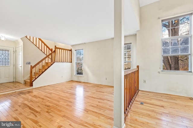 unfurnished living room with stairway and hardwood / wood-style floors