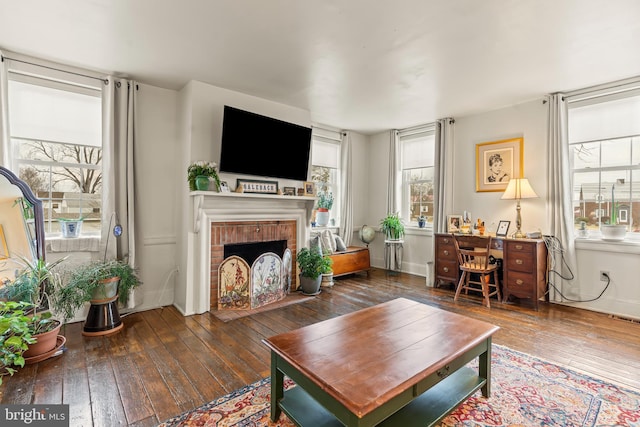 living area featuring hardwood / wood-style flooring, a fireplace, and visible vents