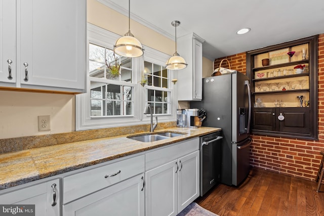 kitchen featuring brick wall, pendant lighting, stainless steel appliances, and a sink