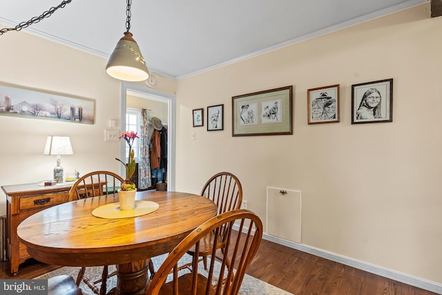 dining room with ornamental molding, dark wood finished floors, and baseboards