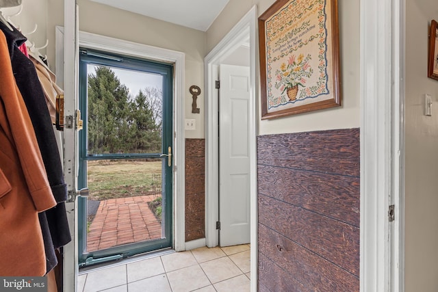 doorway featuring tile walls and light tile patterned floors