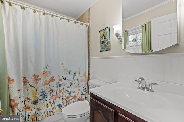 full bath featuring curtained shower, toilet, a wainscoted wall, vanity, and ornamental molding