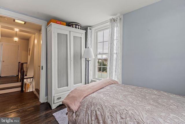 bedroom with a closet and dark wood finished floors