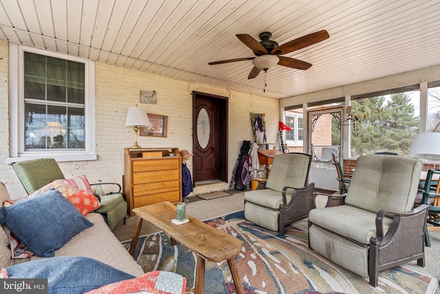 sunroom / solarium with a ceiling fan and wood ceiling