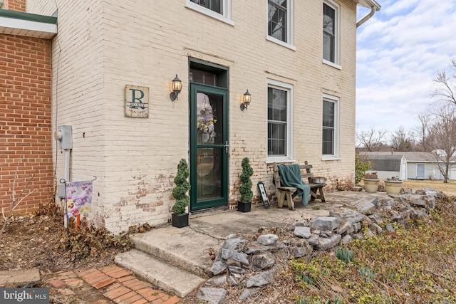 entrance to property featuring brick siding