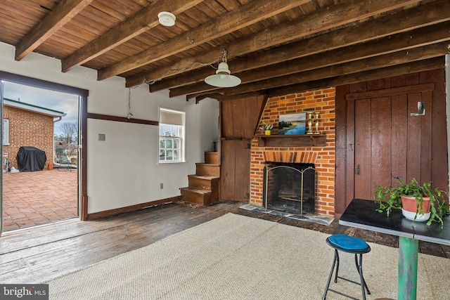 unfurnished living room featuring wood ceiling, a brick fireplace, baseboards, and hardwood / wood-style flooring