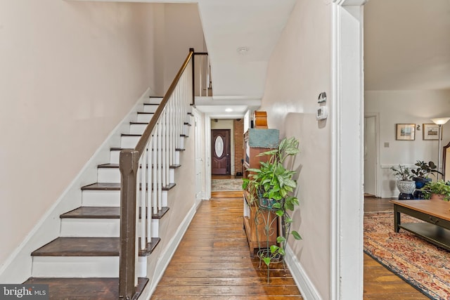 entrance foyer featuring hardwood / wood-style flooring, baseboards, and stairway