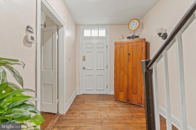 entrance foyer featuring stairway, light wood-type flooring, and baseboards