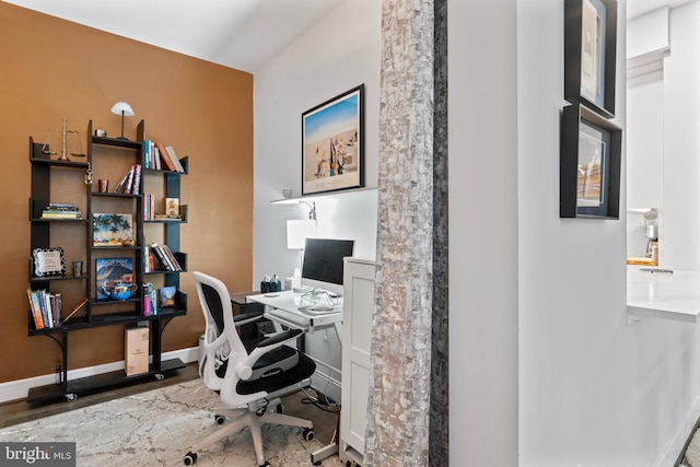 office space featuring baseboards and wood finished floors