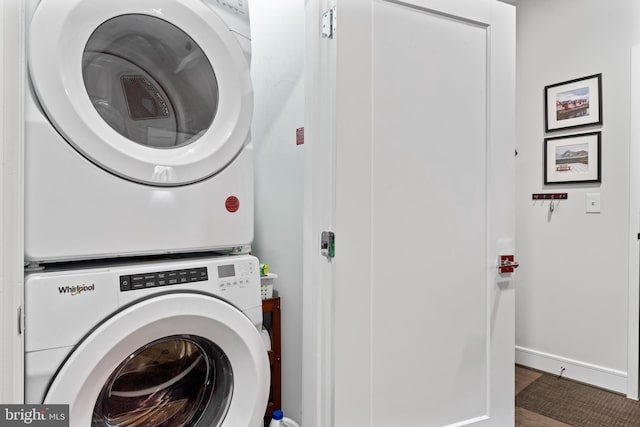 laundry room with stacked washer and dryer, laundry area, and baseboards