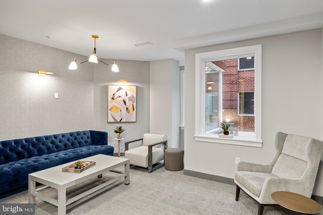 living room featuring wallpapered walls, baseboards, and light colored carpet