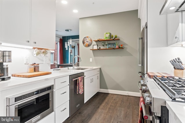 kitchen featuring appliances with stainless steel finishes, light countertops, white cabinetry, and a sink