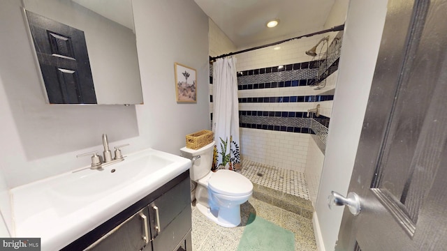 full bathroom with a stall shower, vanity, toilet, and speckled floor