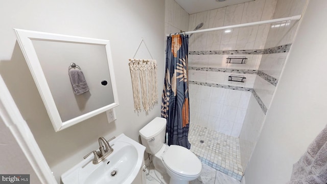 bathroom featuring a stall shower, a sink, and toilet