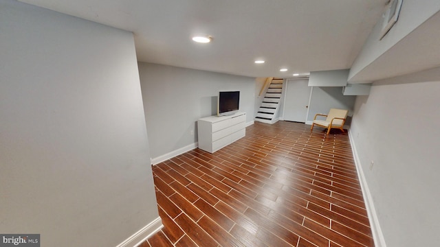 finished basement with stairs, baseboards, dark wood-style flooring, and recessed lighting