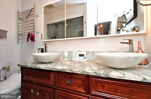 full bathroom featuring toilet, vanity, visible vents, radiator, and an enclosed shower