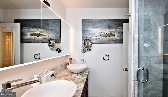 bathroom with double vanity, a stall shower, and a sink