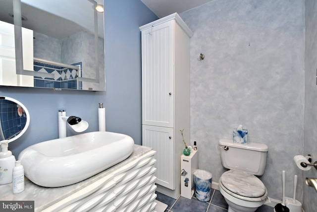 bathroom featuring a sink, toilet, and tile patterned floors