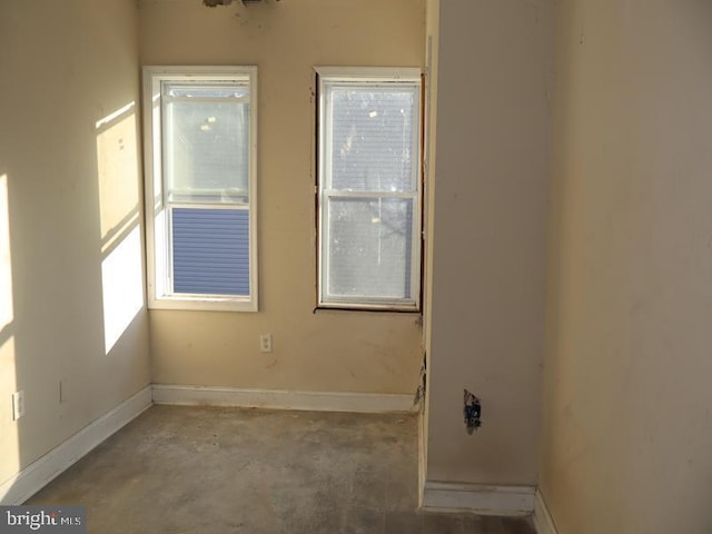 empty room with plenty of natural light and baseboards