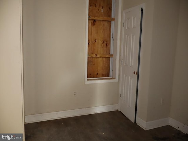 unfurnished room featuring concrete floors and baseboards