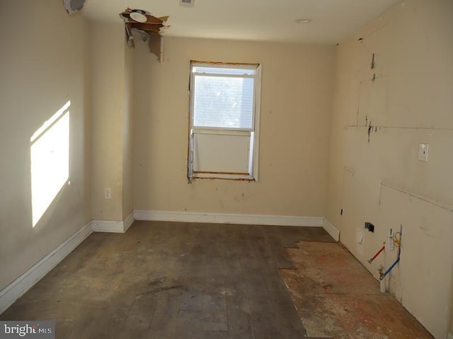 empty room with hardwood / wood-style flooring, visible vents, and baseboards