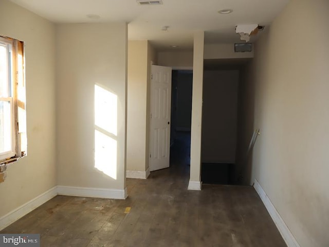 unfurnished room with wood finished floors, visible vents, and baseboards