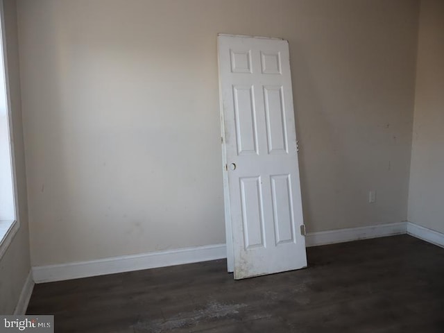 empty room featuring wood finished floors and baseboards