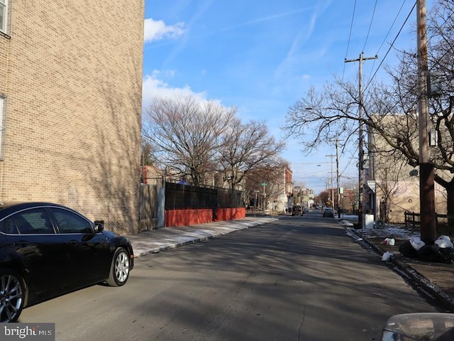 view of road featuring sidewalks, street lighting, and curbs