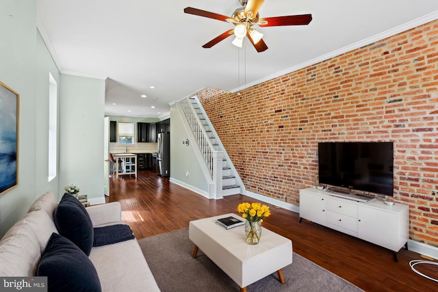 living area with crown molding, recessed lighting, dark wood-type flooring, baseboards, and stairs