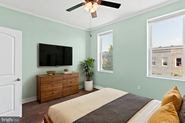 bedroom with baseboards, crown molding, and wood finished floors