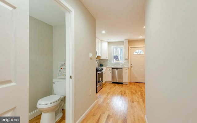 hall with baseboards, recessed lighting, and light wood-style floors